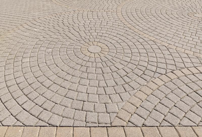 A close up of a circular pattern on a brick pavement.