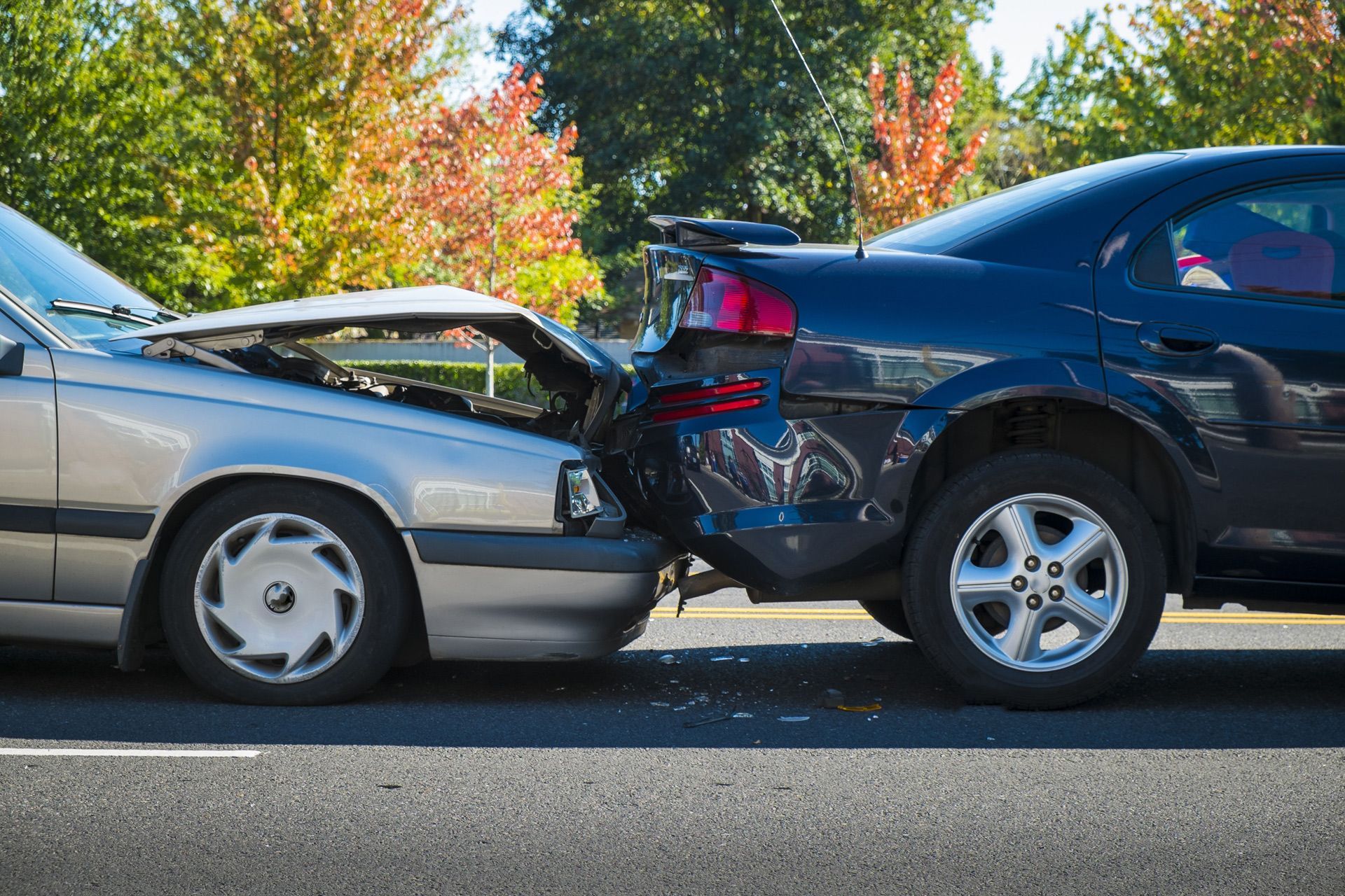 Two cars are involved in a car accident on the side of the road.