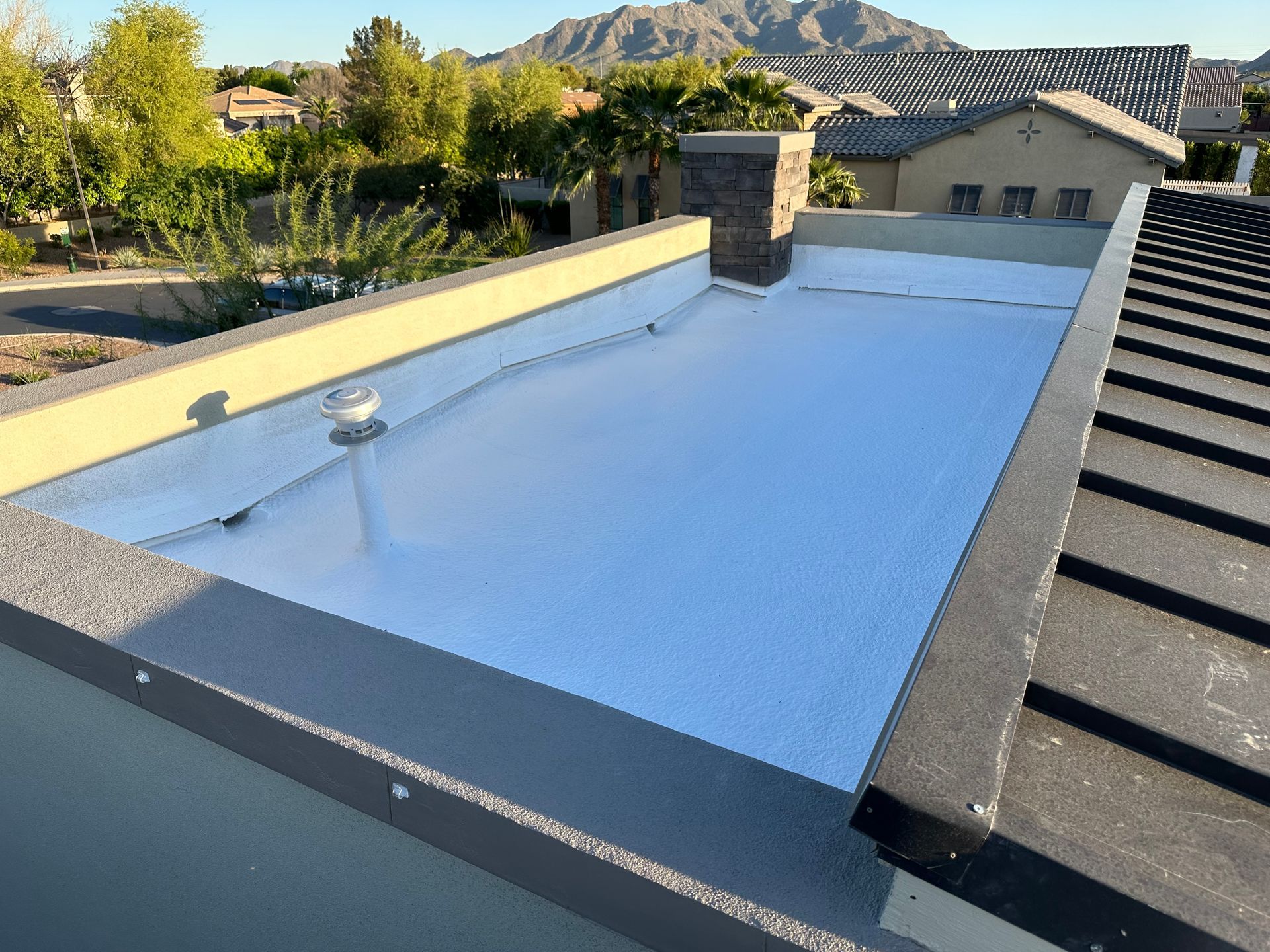 A white roof with a chimney on top of it.