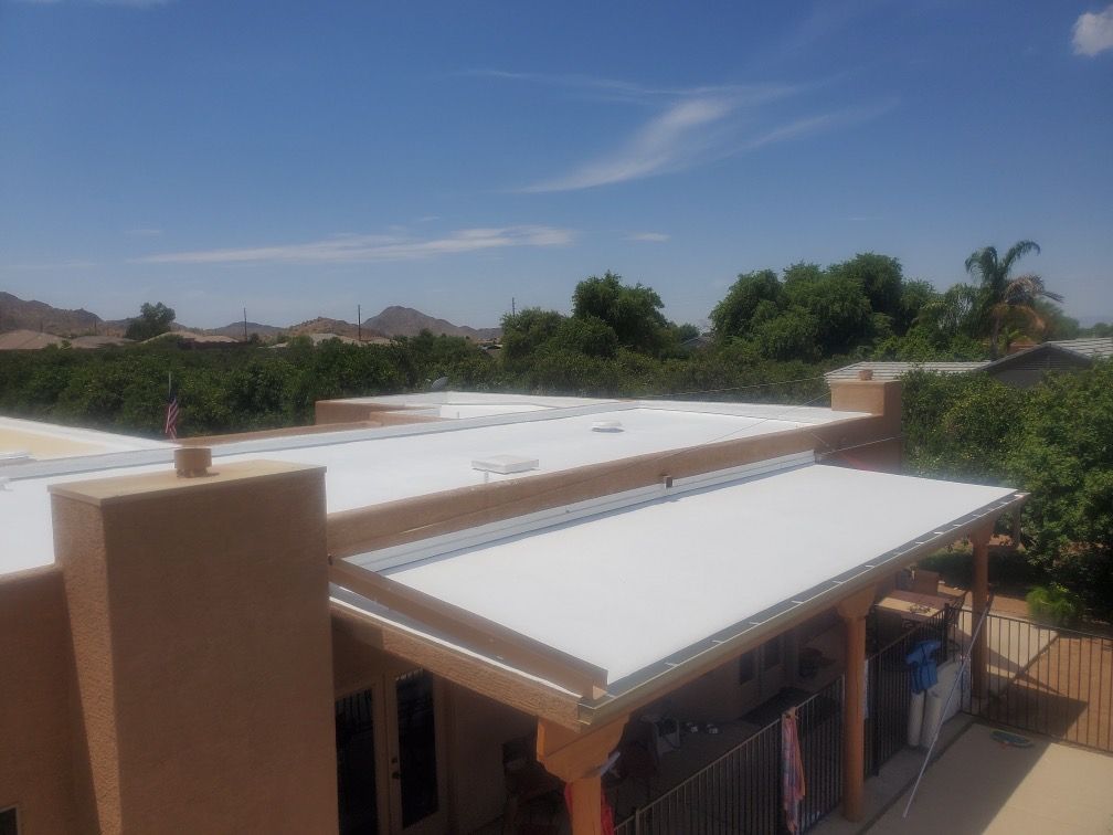 An aerial view of a house with a white roof.