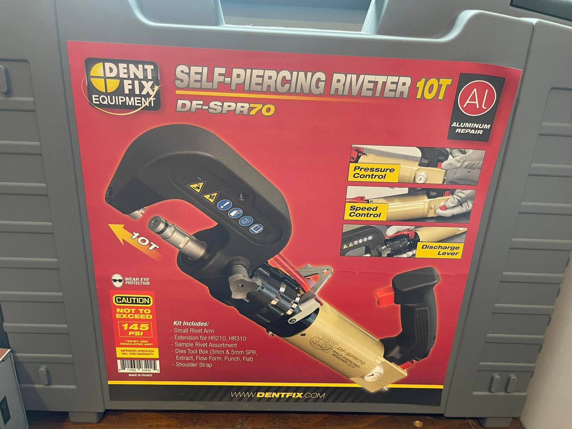 Red self-piercing riveter tool kit box on a store shelf, with product photos and yellow branding.