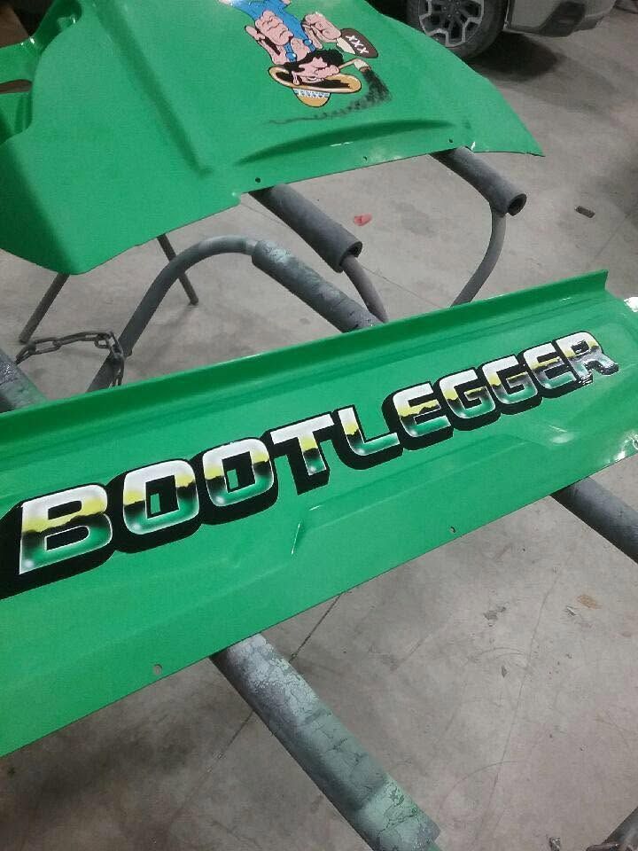 Green foot pegs on a BOOTLEGGER vehicle frame in a workshop