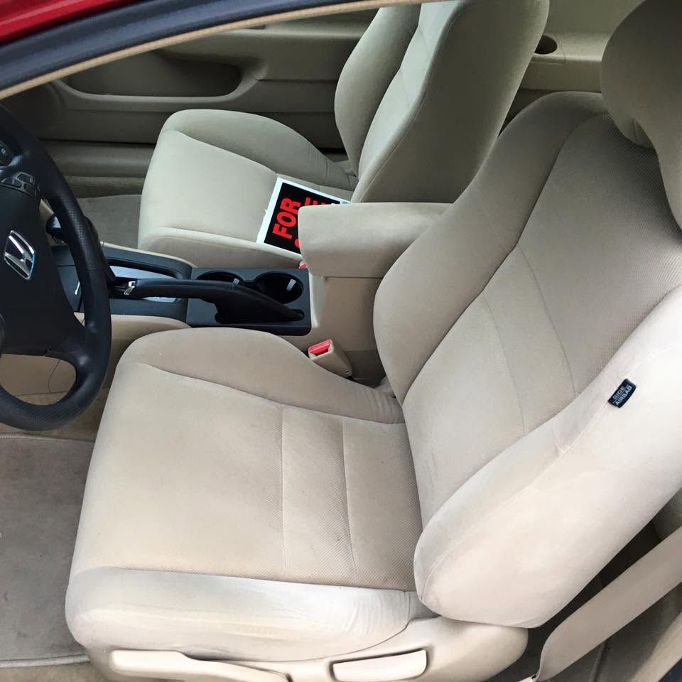 Beige car front seats and center console viewed from the passenger side