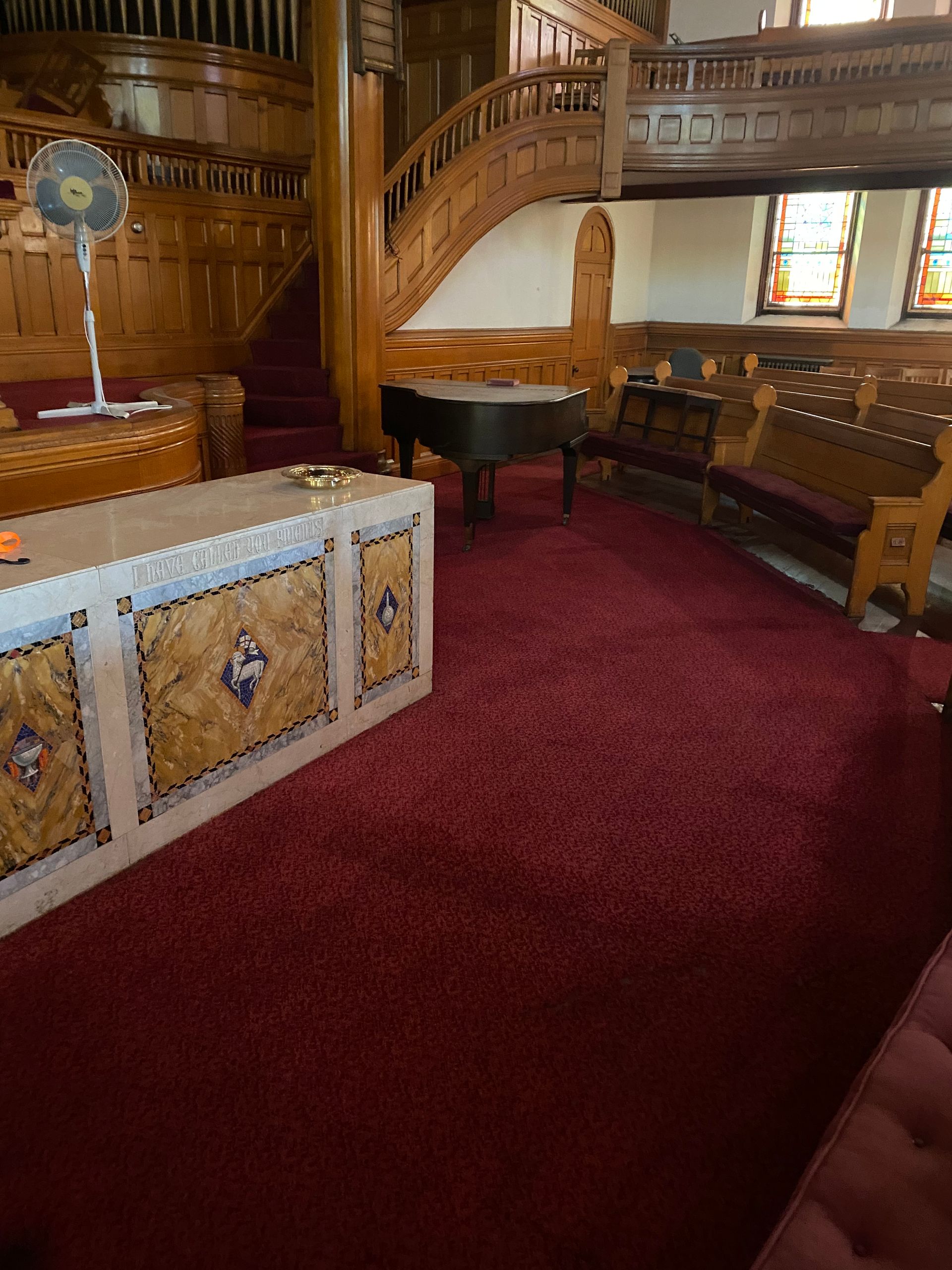 A church with a piano and a fan on the floor