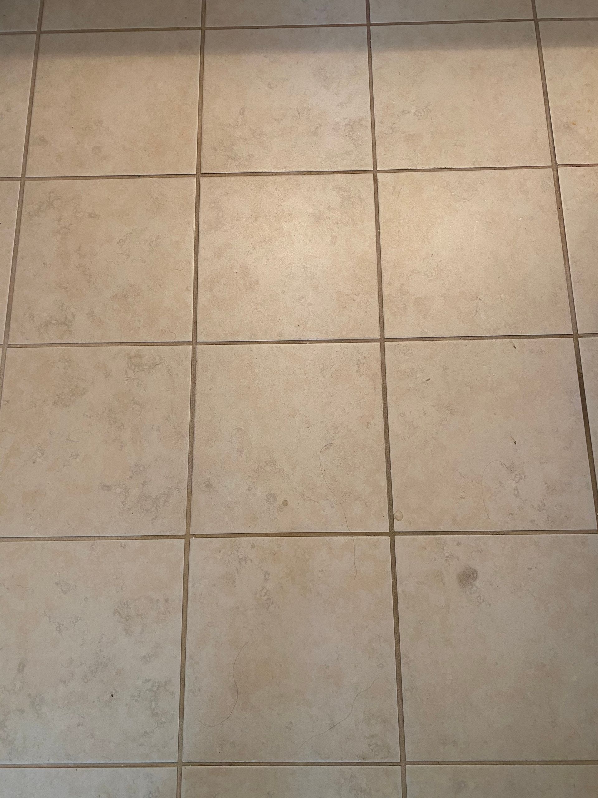 A close up of a tiled floor with a few cracks