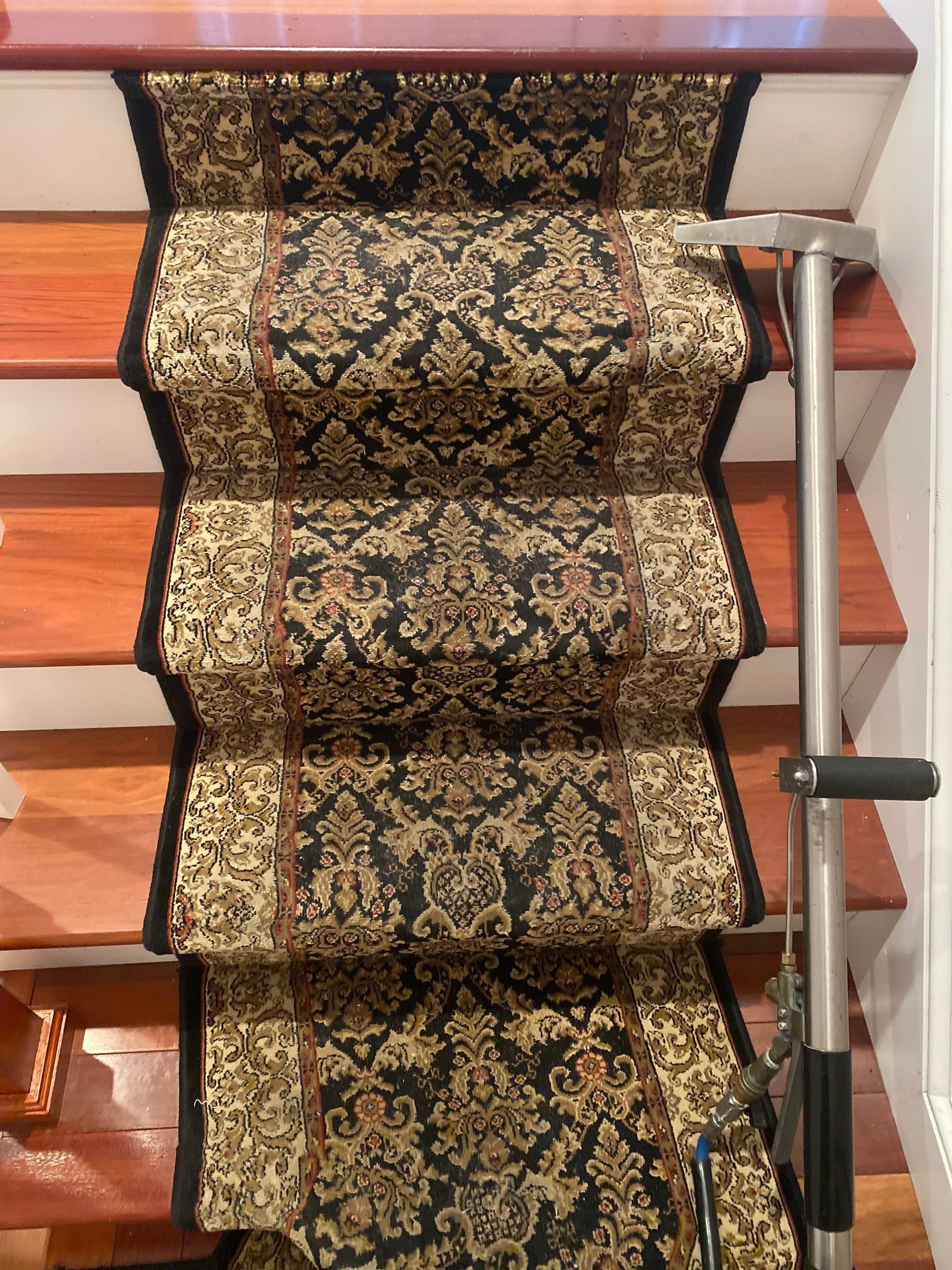 A staircase with a black and gold carpet on it.