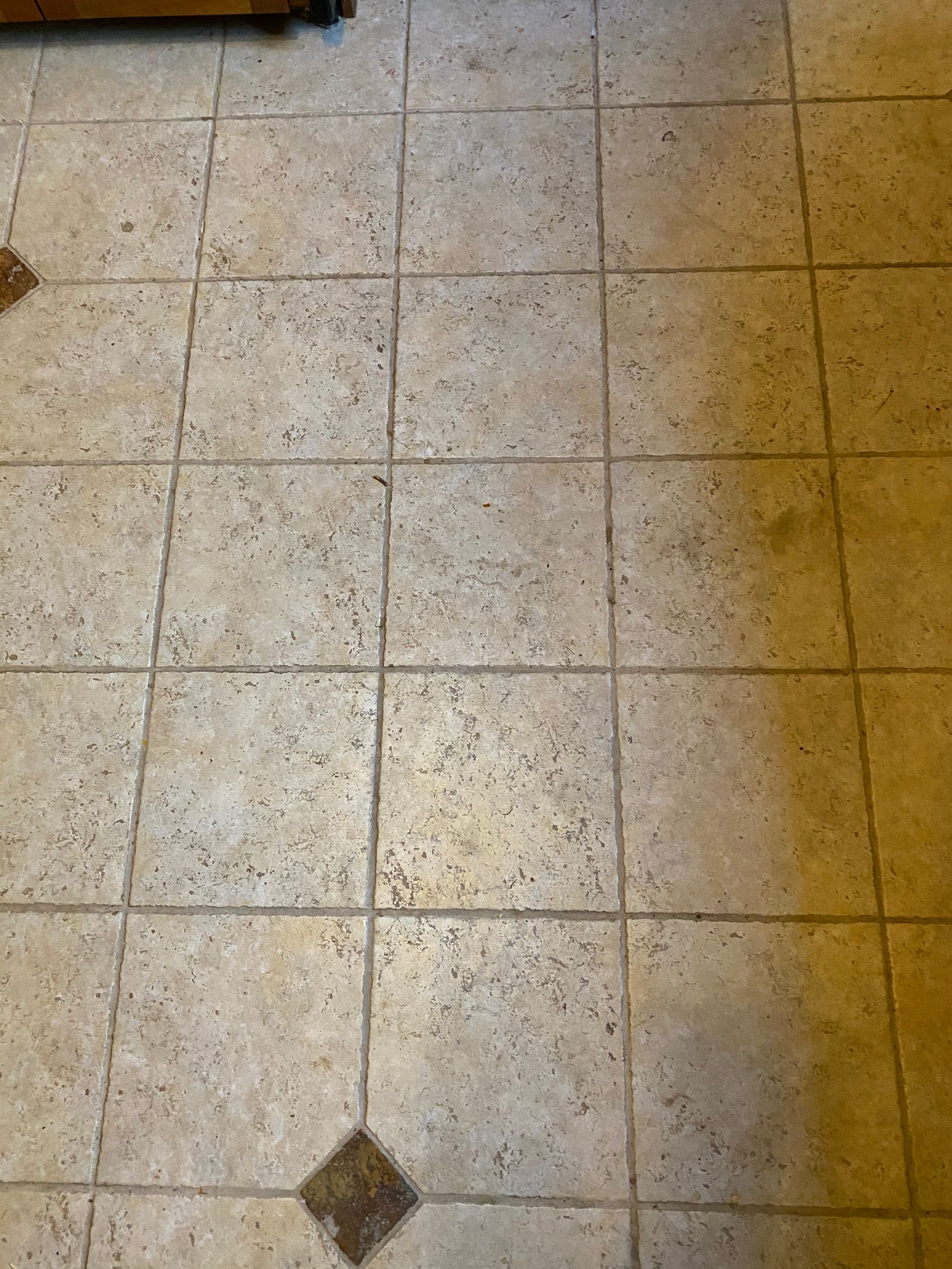 A close up of a tiled floor with a square in the middle.