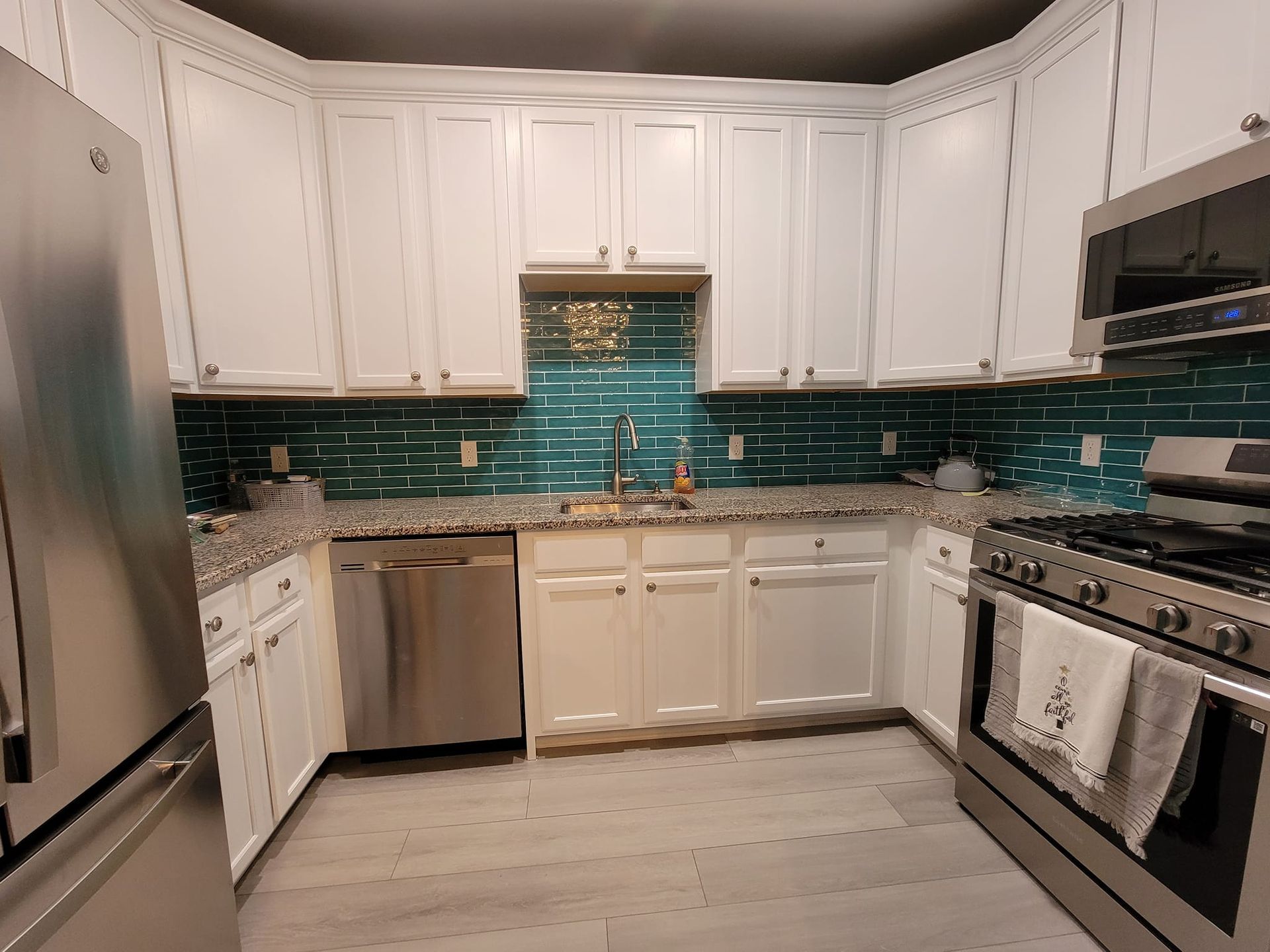 A kitchen with white cabinets and stainless steel appliances