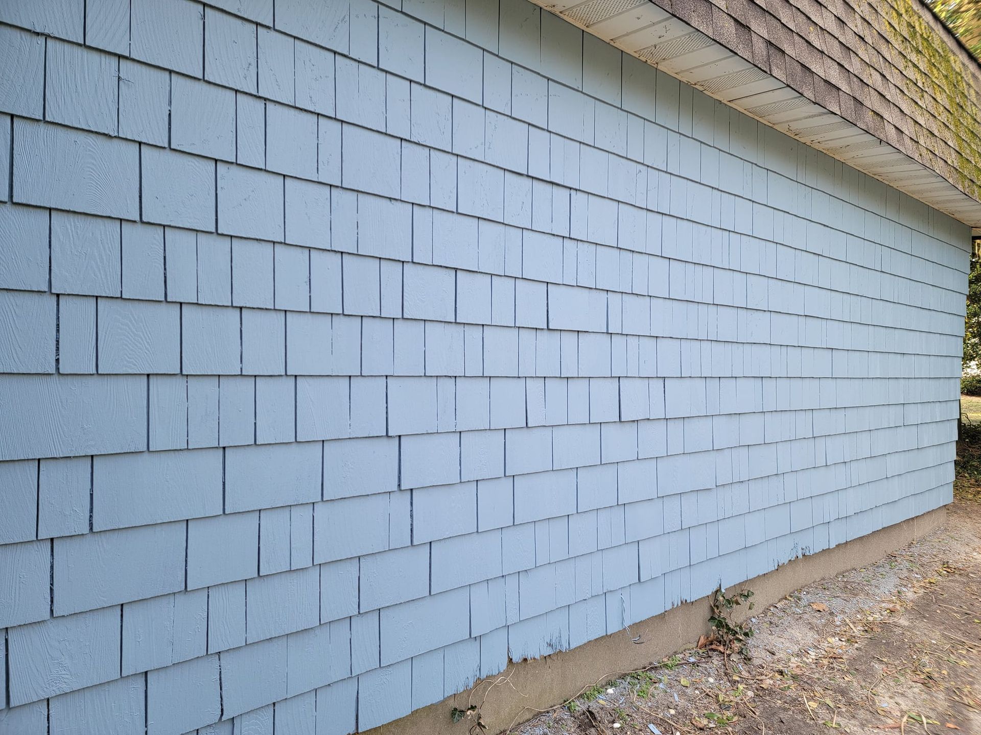 A blue brick wall with a brown roof