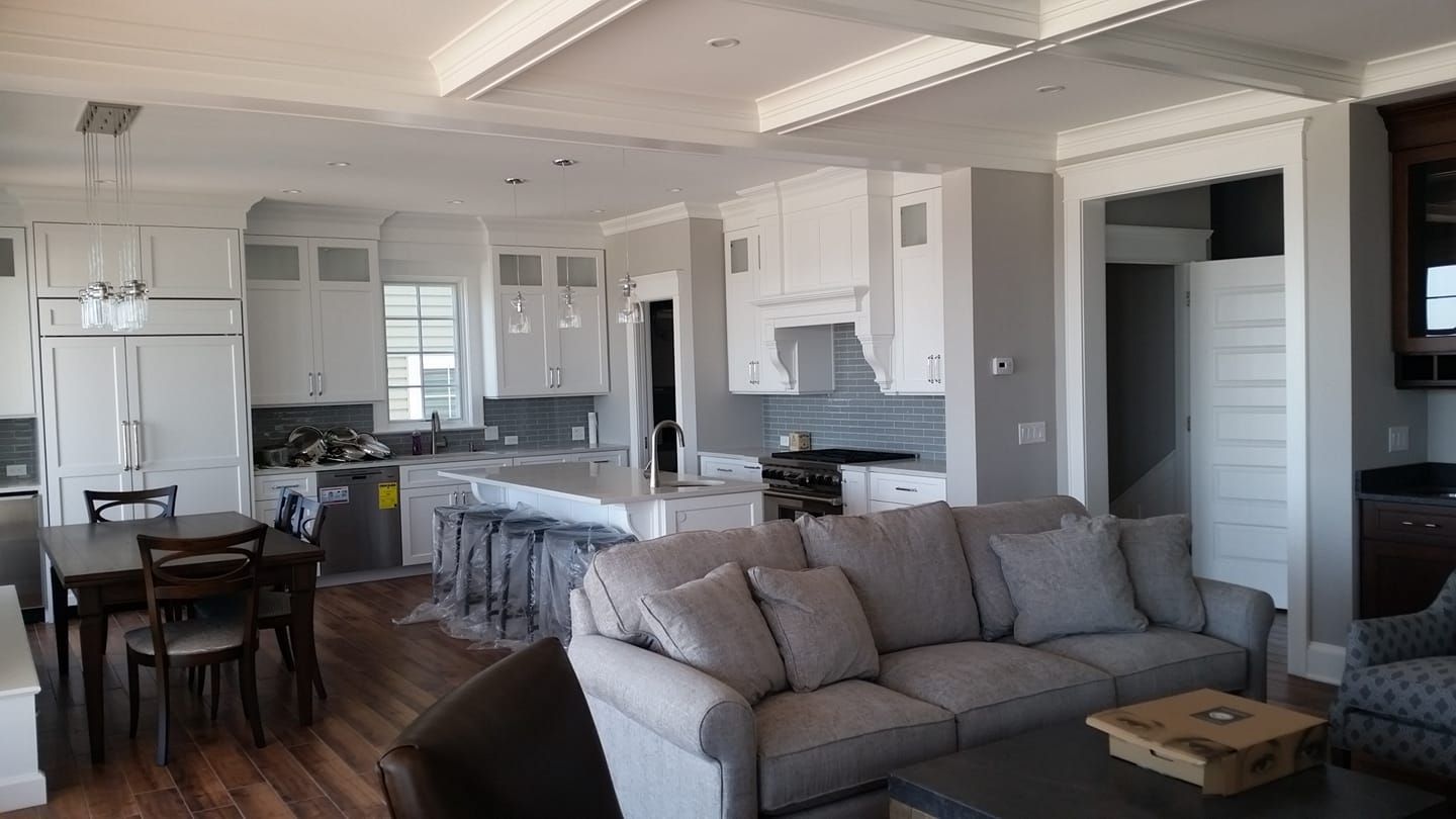 A living room with a couch , table , chairs and a kitchen.