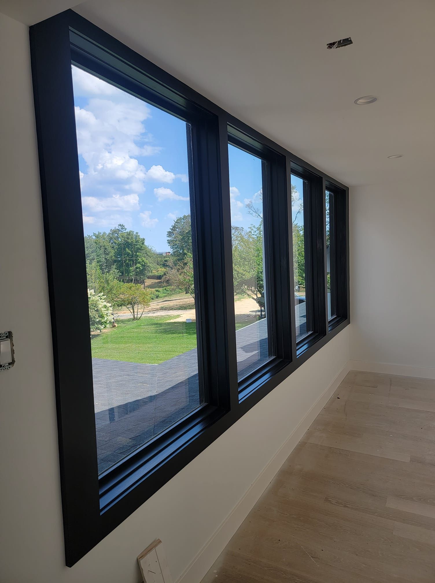 A room with a lot of windows and a view of a park.