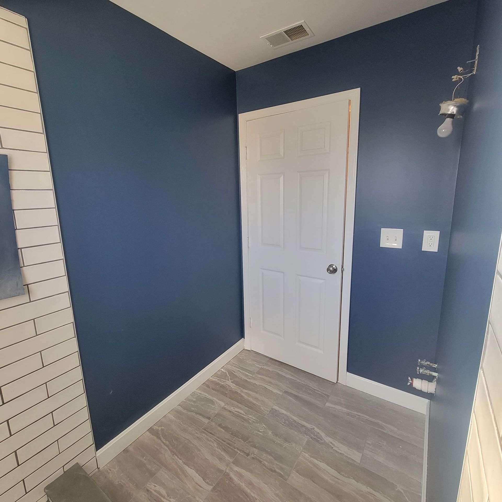 A bathroom with blue walls and a white door.