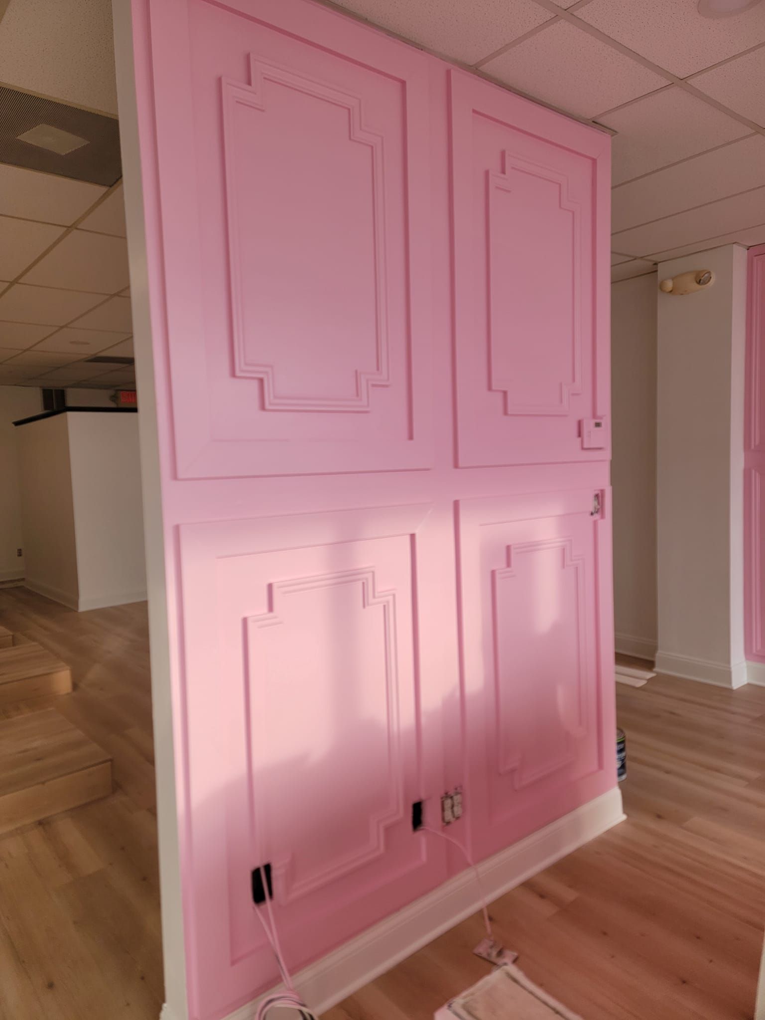 A room with pink cabinets and a wooden floor.