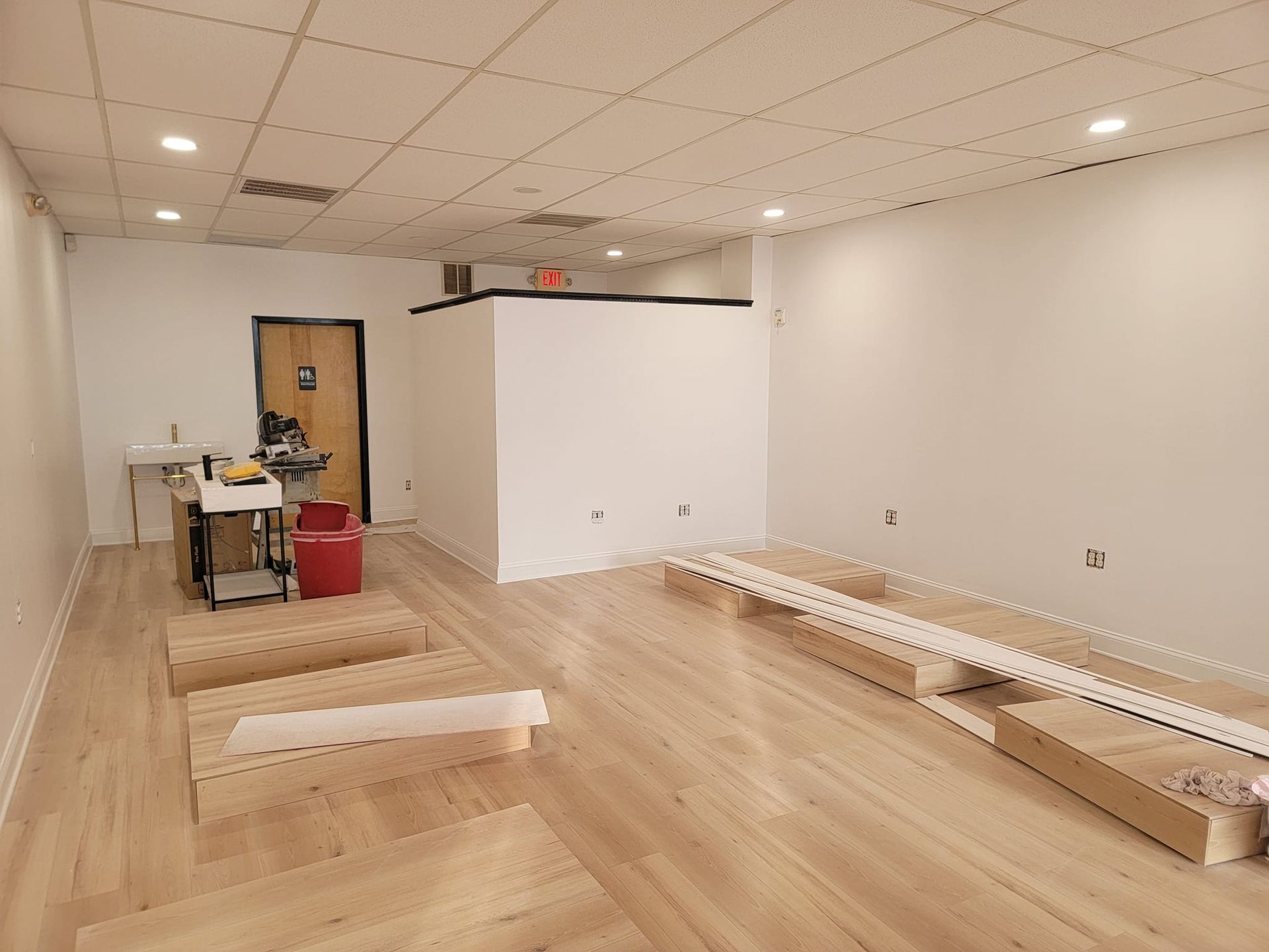 A large empty room with wooden floors and white walls.
