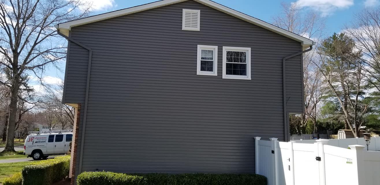 A gray house with a white van parked in front of it.