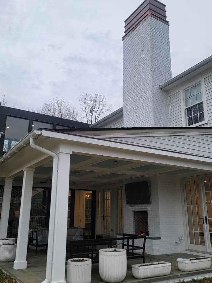 A white house with a large chimney on top of it