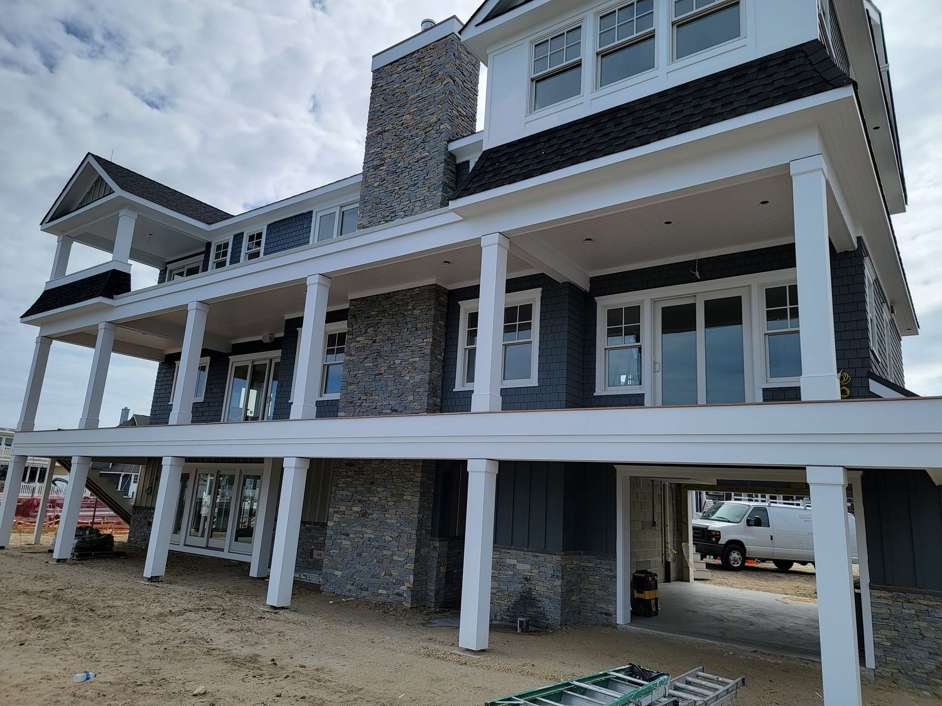 A large house is being built on stilts on the beach.