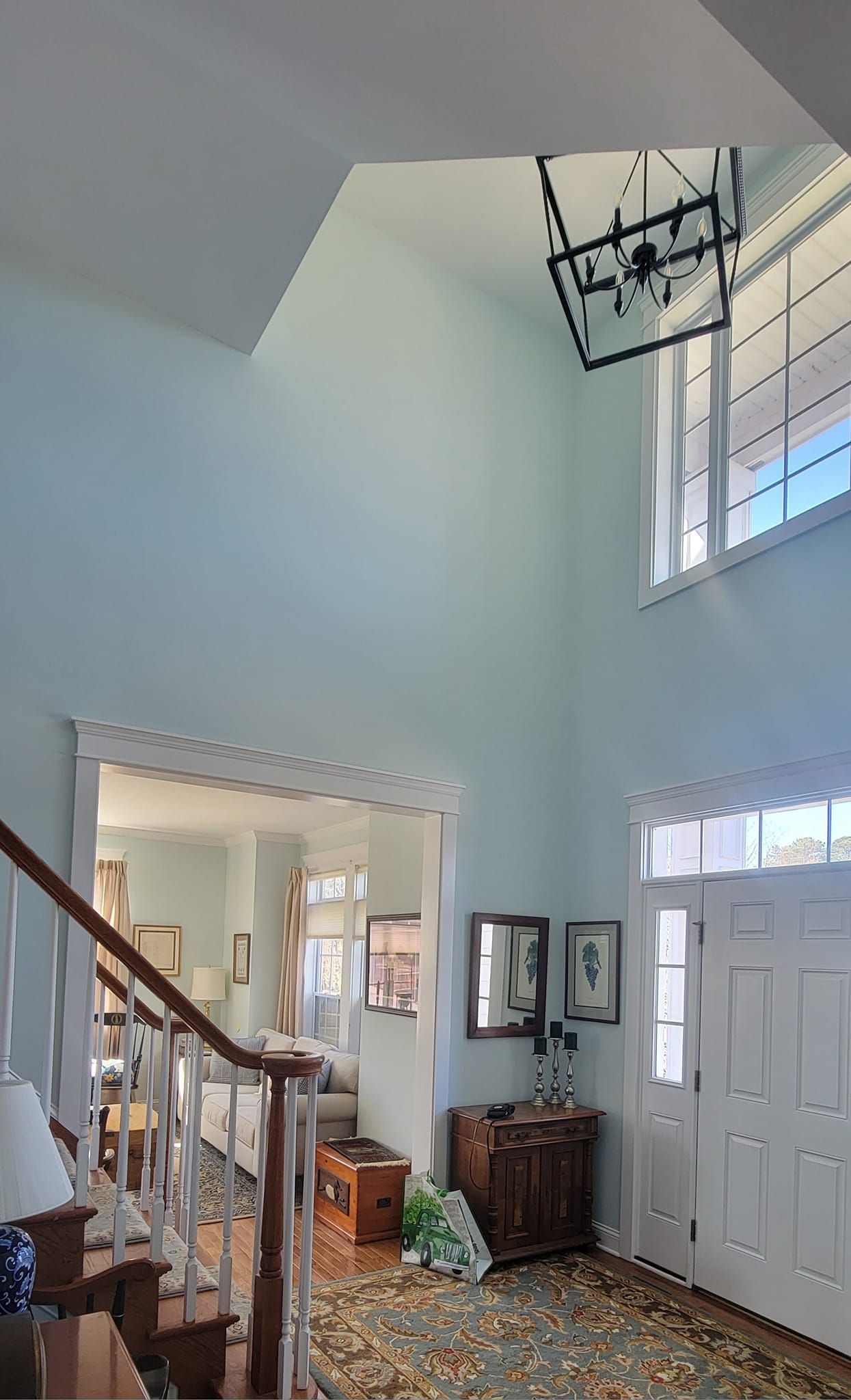 A hallway with stairs and a chandelier hanging from the ceiling