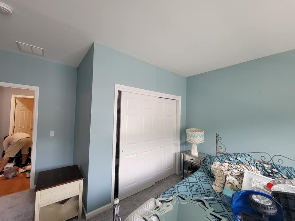 A bedroom with a bed , nightstand , lamp and closet.