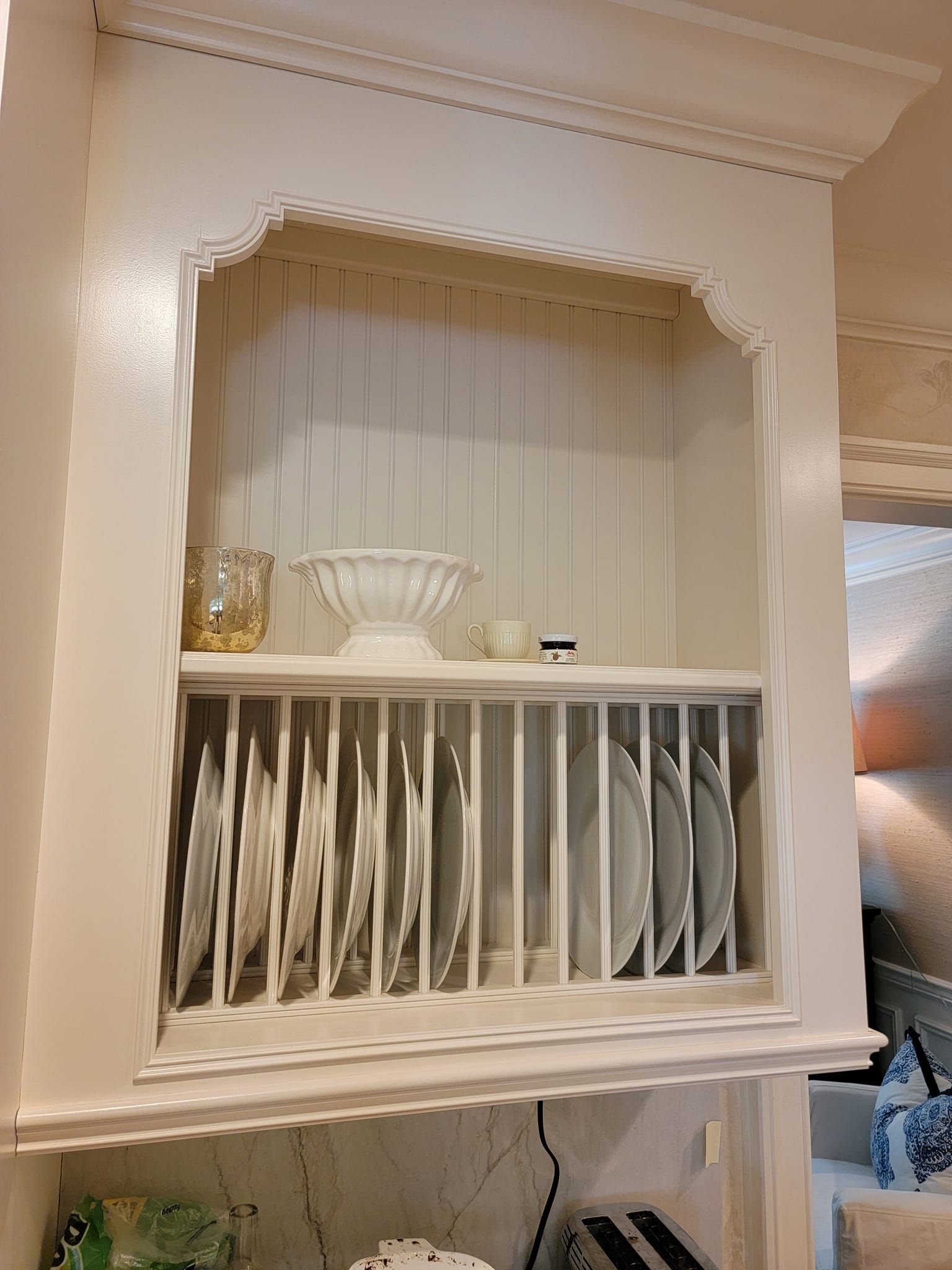 A white shelf with plates and bowls on it