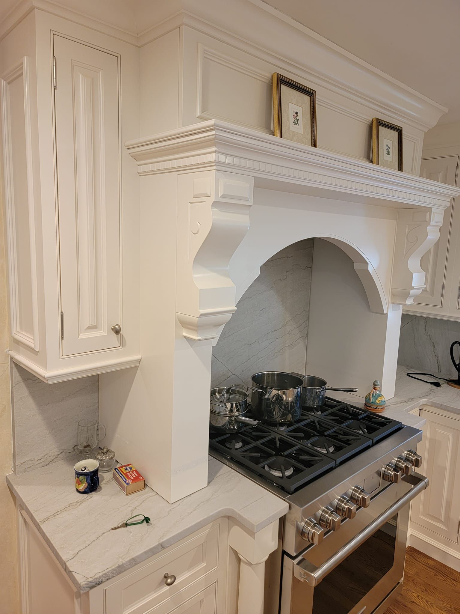 A kitchen with a stove top oven and white cabinets