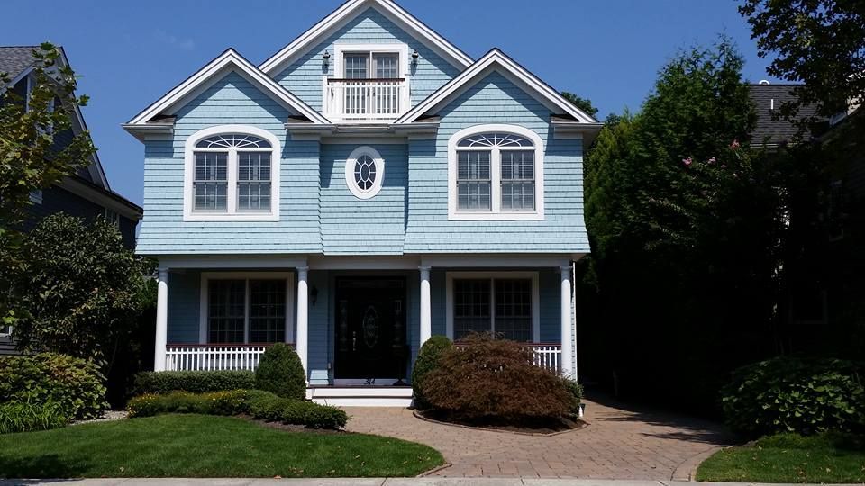 A blue house with white trim and a porch