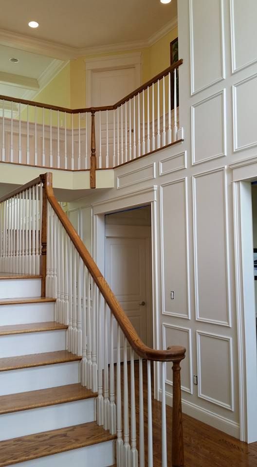 A staircase with white steps and a wooden railing in a house.
