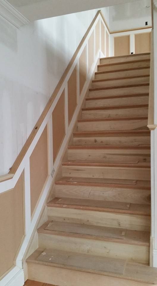 A wooden staircase with a white railing in a house.