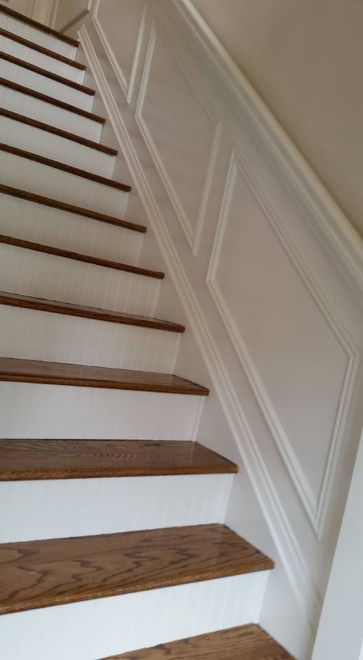 A set of stairs with wooden steps and a white railing.