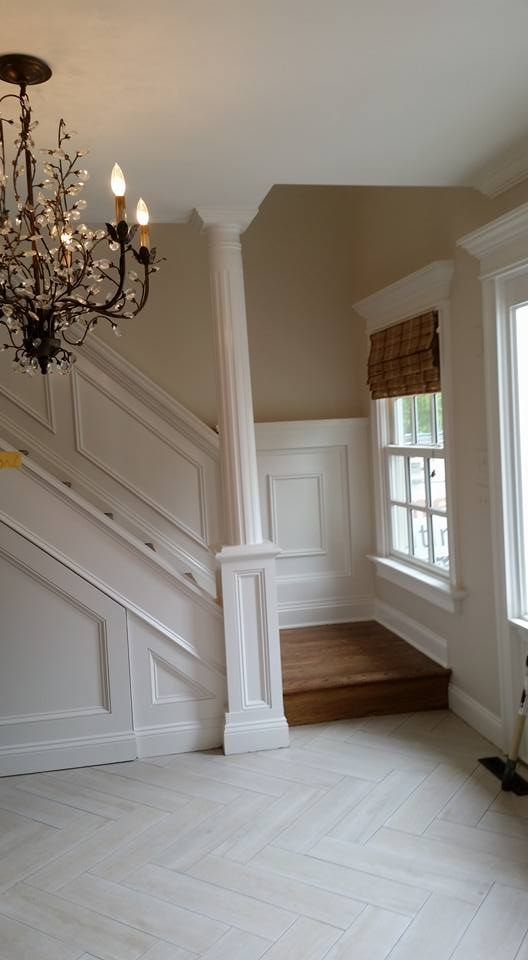 There is a chandelier hanging from the ceiling in the middle of the room.