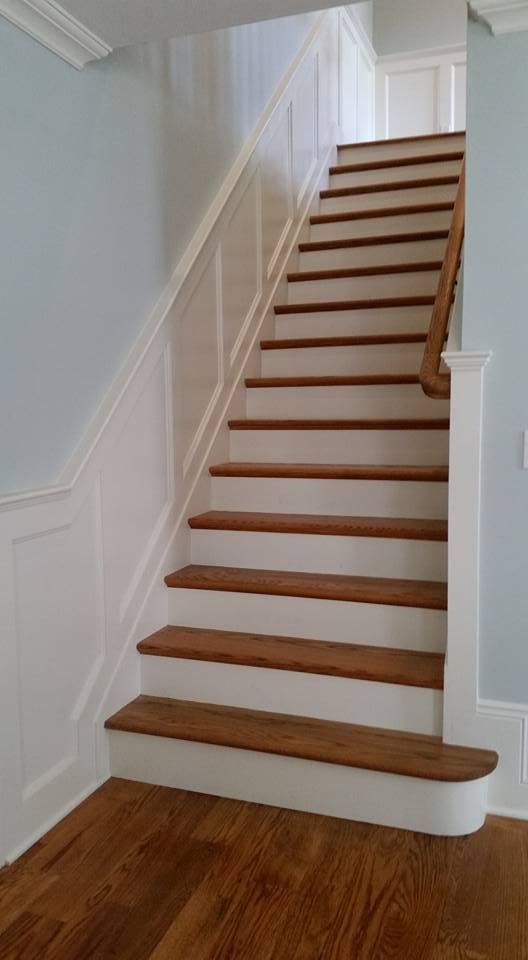 A staircase with white steps and wooden steps in a house.