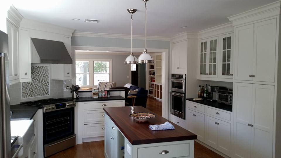A kitchen with white cabinets and a large island in the middle.