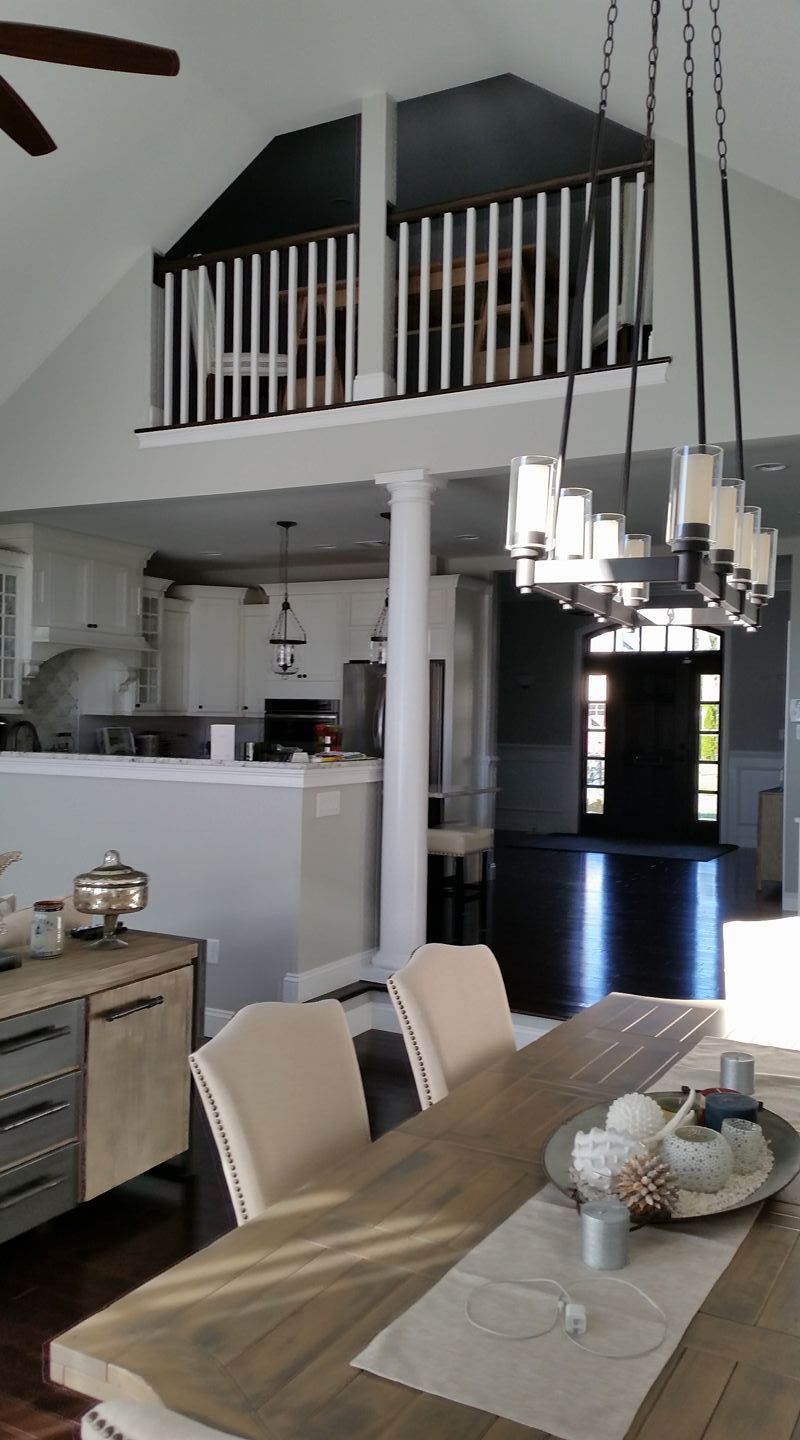A dining room table and chairs in a house with a balcony.
