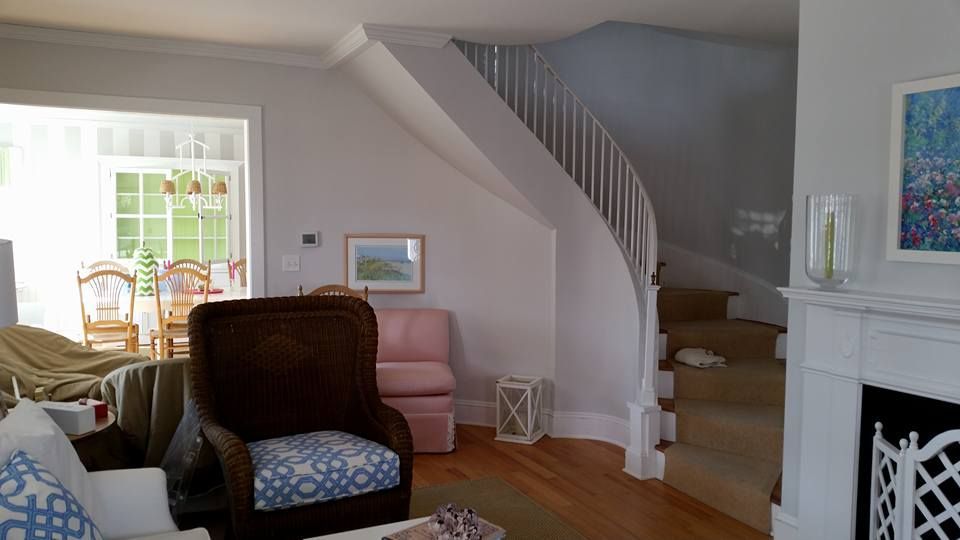 A living room with a fireplace and stairs leading up to the second floor.