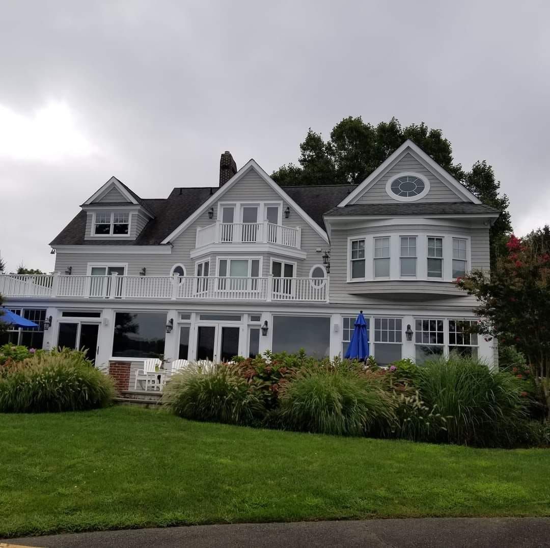 A large white house with a blue umbrella in front of it