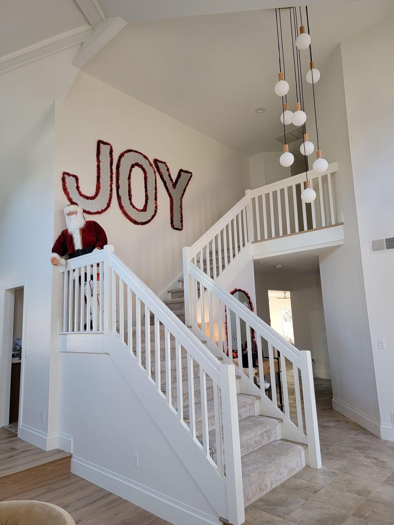 A white staircase with the word joy painted on the wall