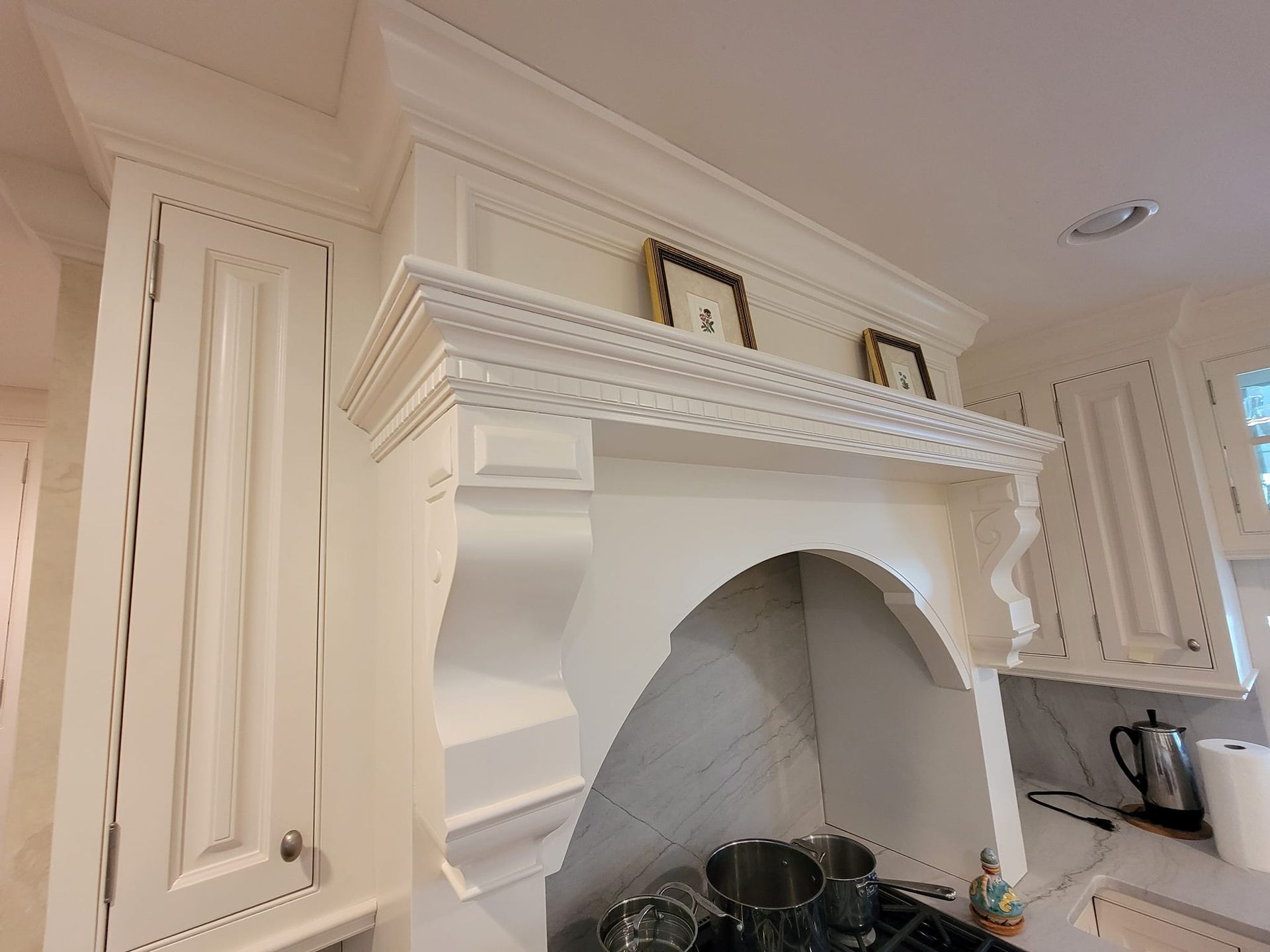 A kitchen with white cabinets and a stove top oven.