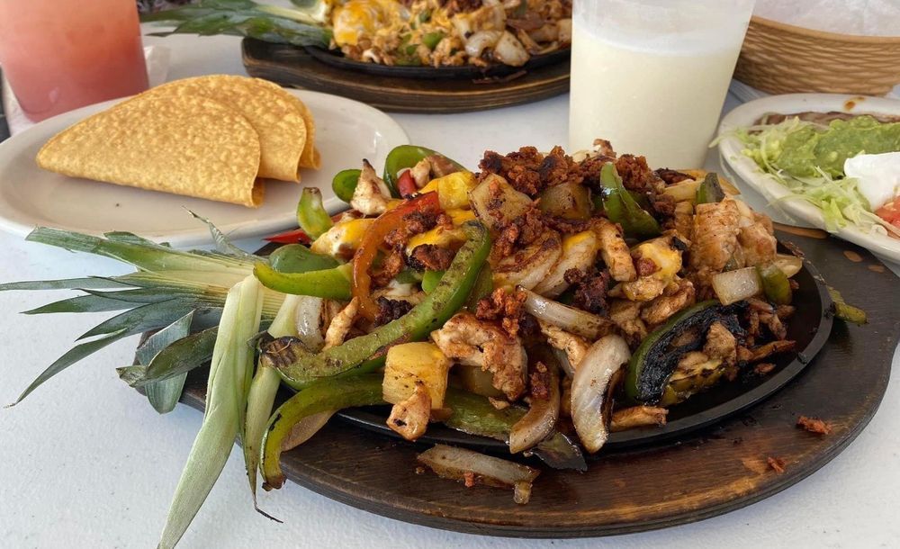 A close up of a plate of food with a drink on a table.