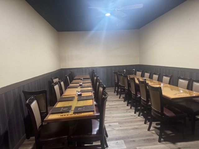 A long room with tables and chairs in it.