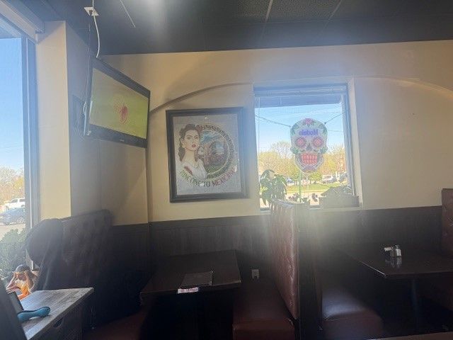 A restaurant with a skull on the window and a picture of a woman on the wall.