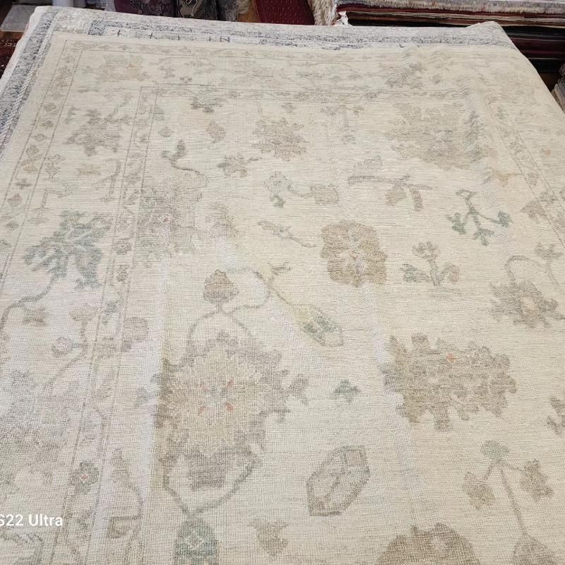 A white rug with a floral pattern is sitting on a table.