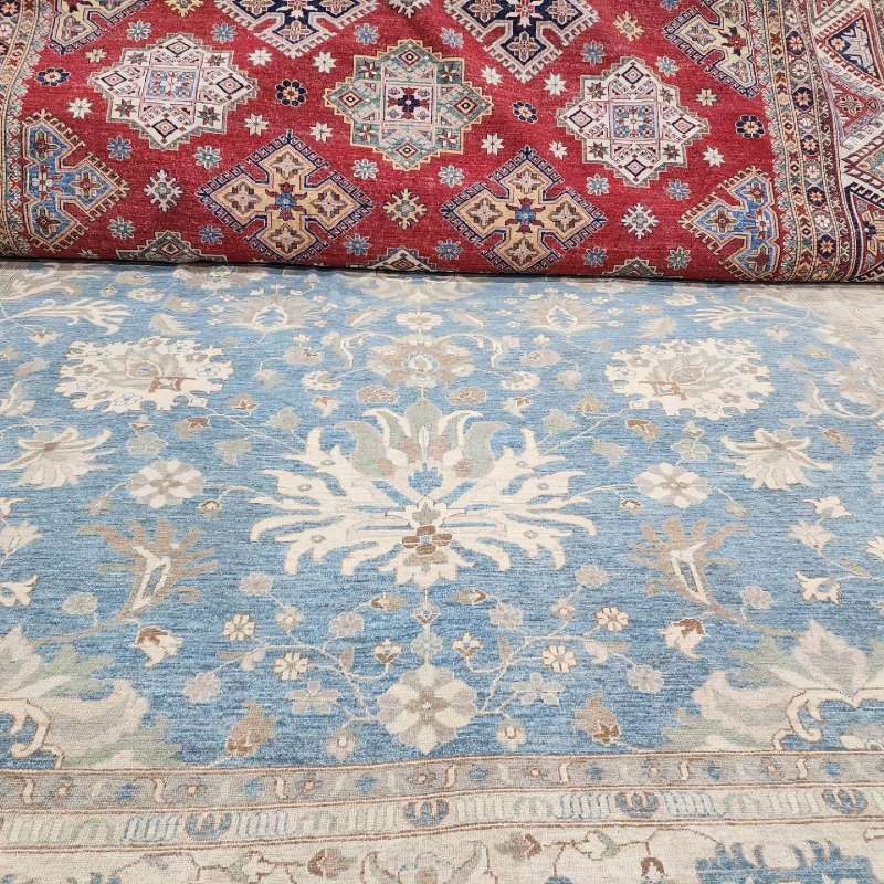 A blue rug is sitting on top of a red rug.