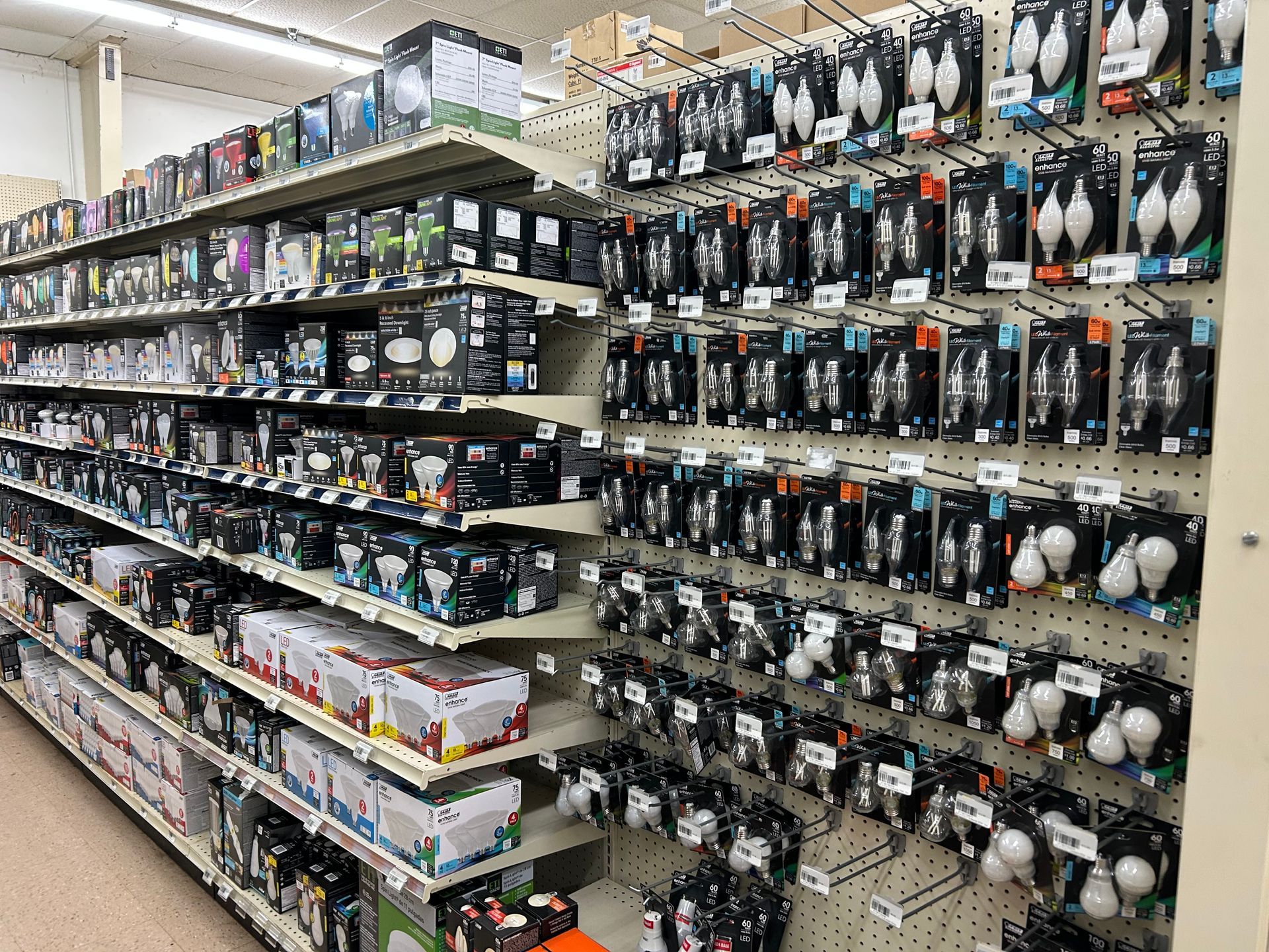 A store aisle filled with lots of different types of light bulbs.