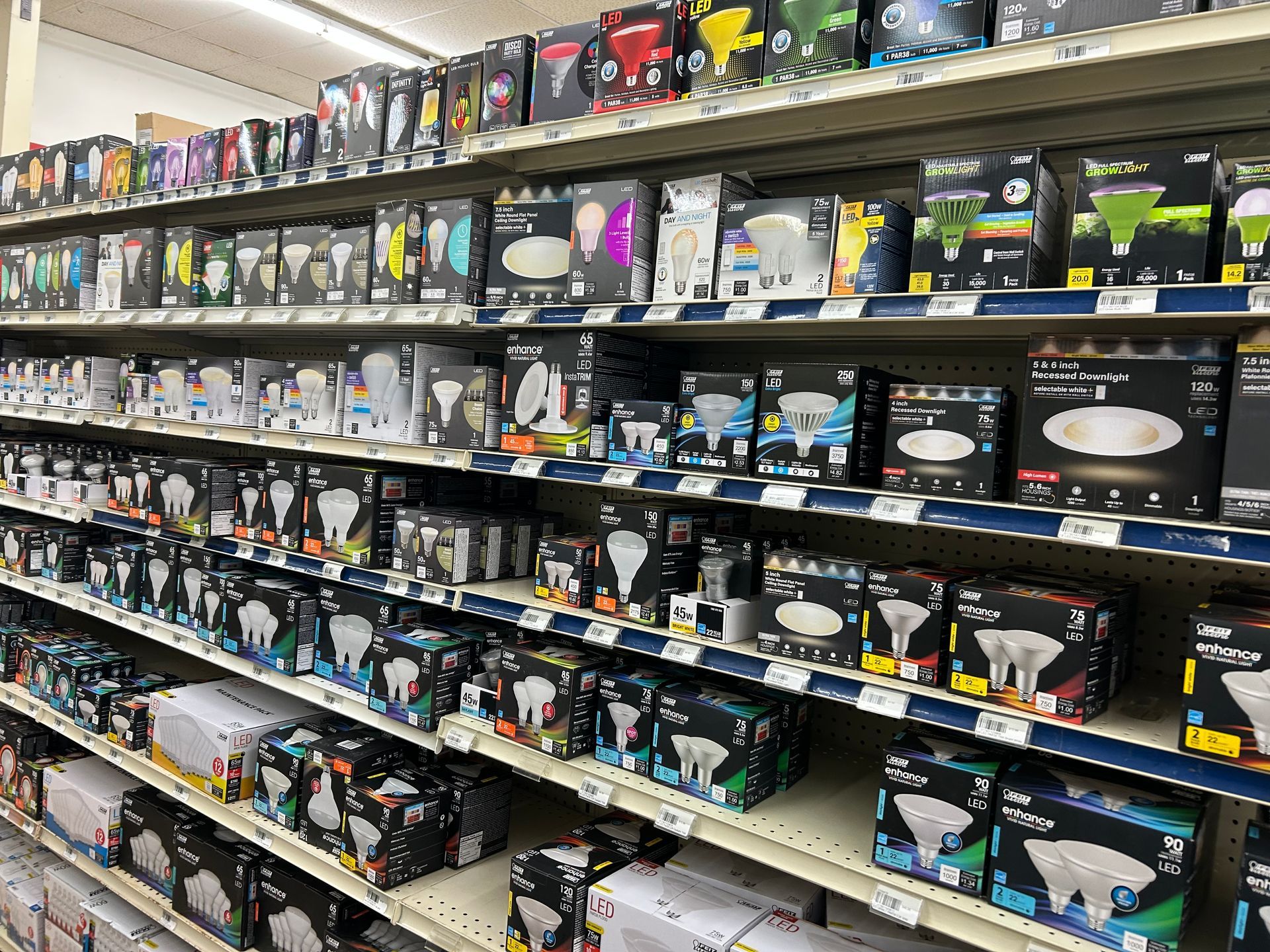 A store aisle filled with lots of different types of light bulbs.