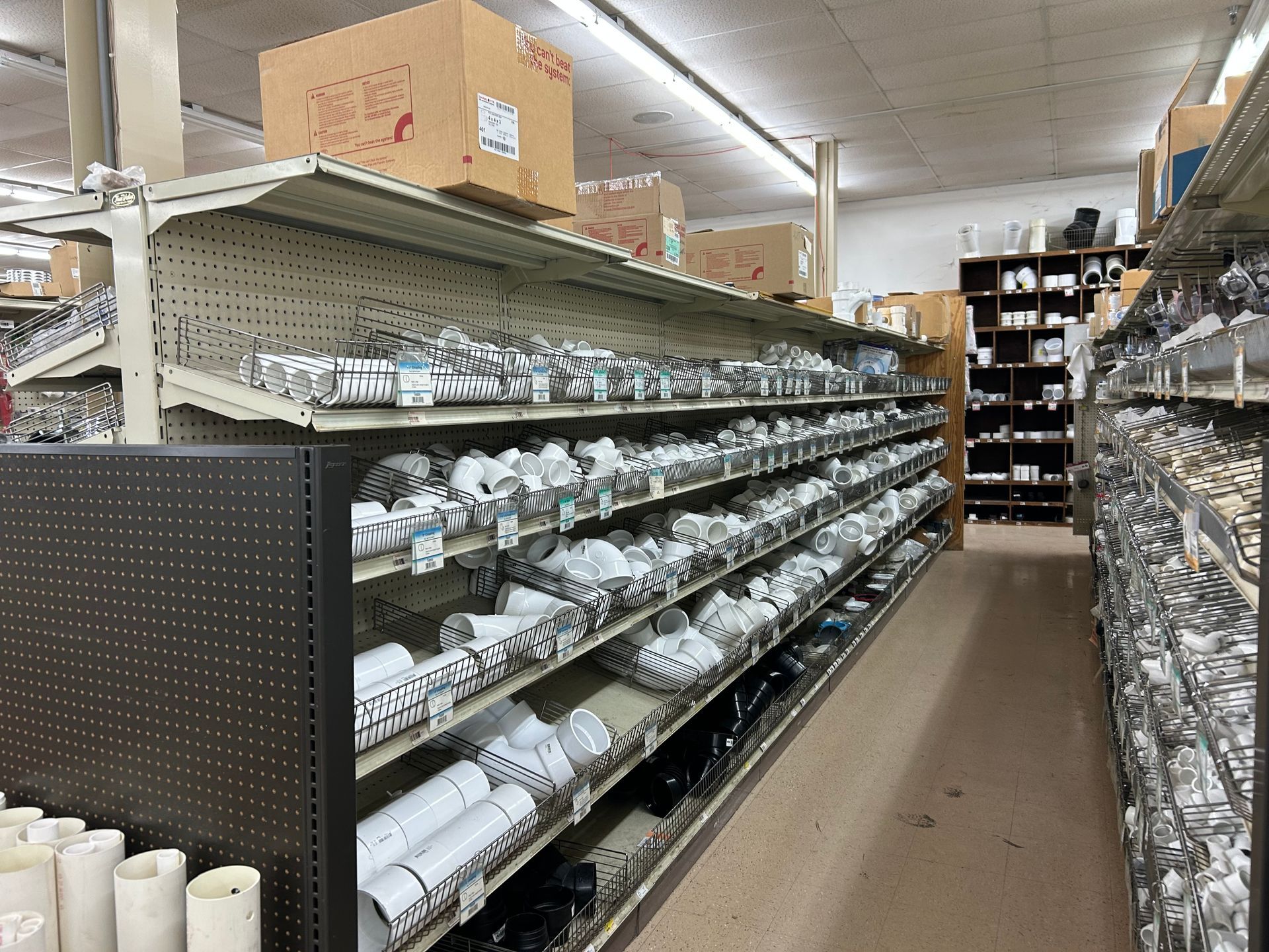A store aisle filled with lots of pipes and boxes.