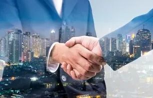 Business handshake over a city skyline, symbolizing a corporate agreement