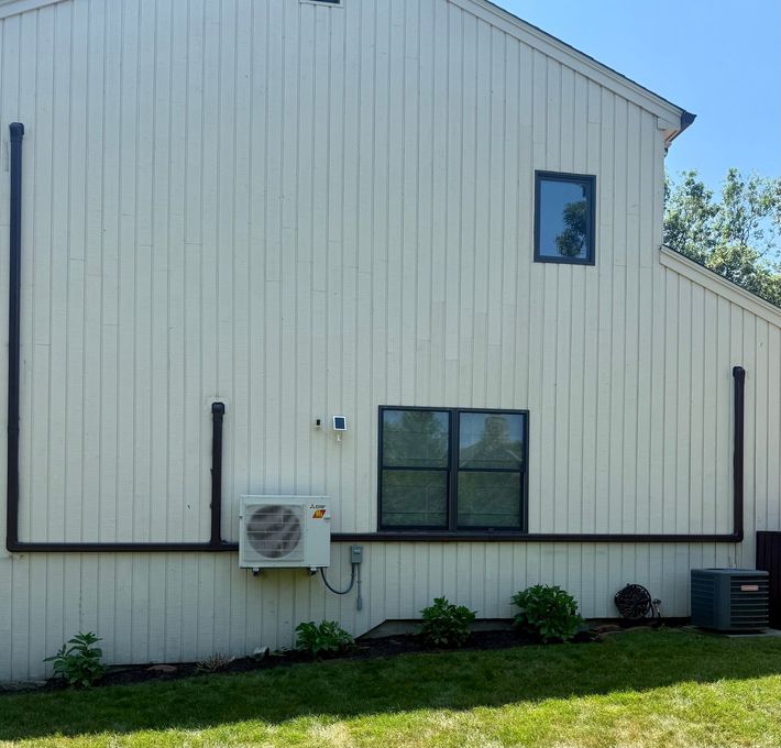 Building exterior with wall-mounted air conditioner and windows with patterned grilles