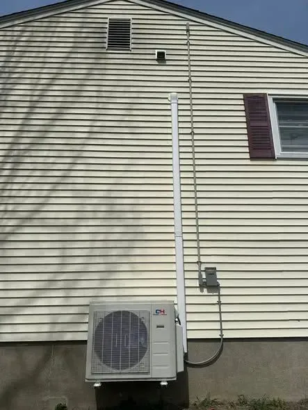 House exterior with white siding and a mounted air conditioner unit near the foundation.