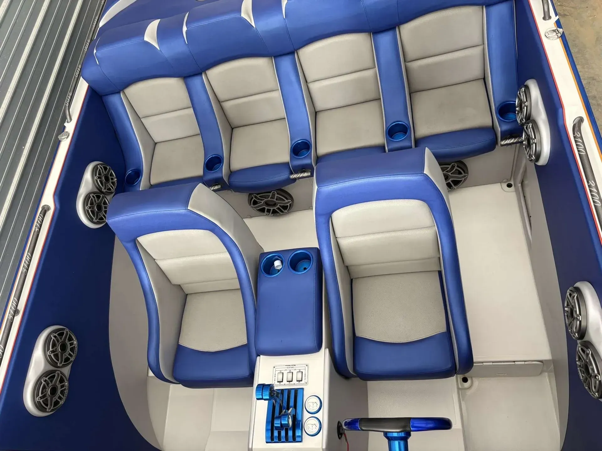 Blue and white speedboat interior with six seats, cup holders, and a center console.