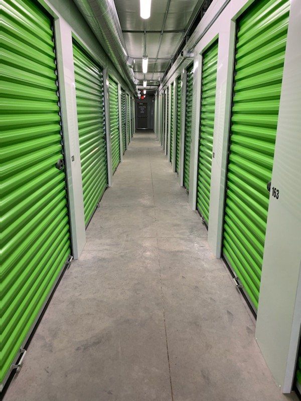 A long hallway filled with green storage units.